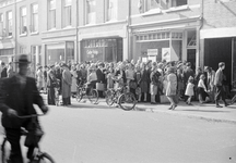 831648 Afbeelding van mensen in de rij voor (vermoedelijk) de voedseldistributie in de winkel in boter, kaas en eieren ...